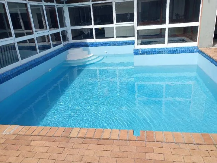 The same indoor pool afterwards, with clear blue water and clean white walls